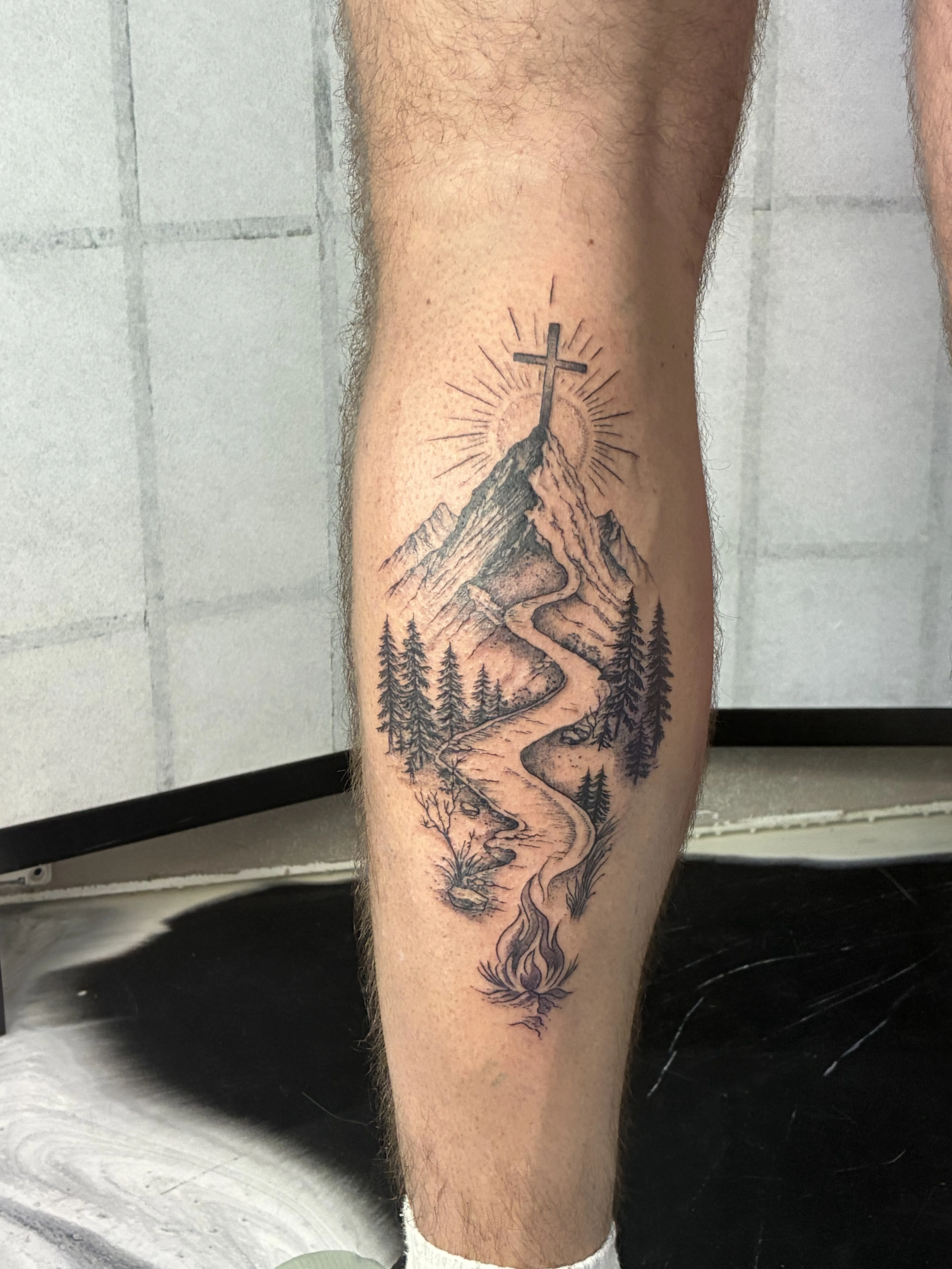 Mountain and cross landscape calf piece, third angle against grey brick wall