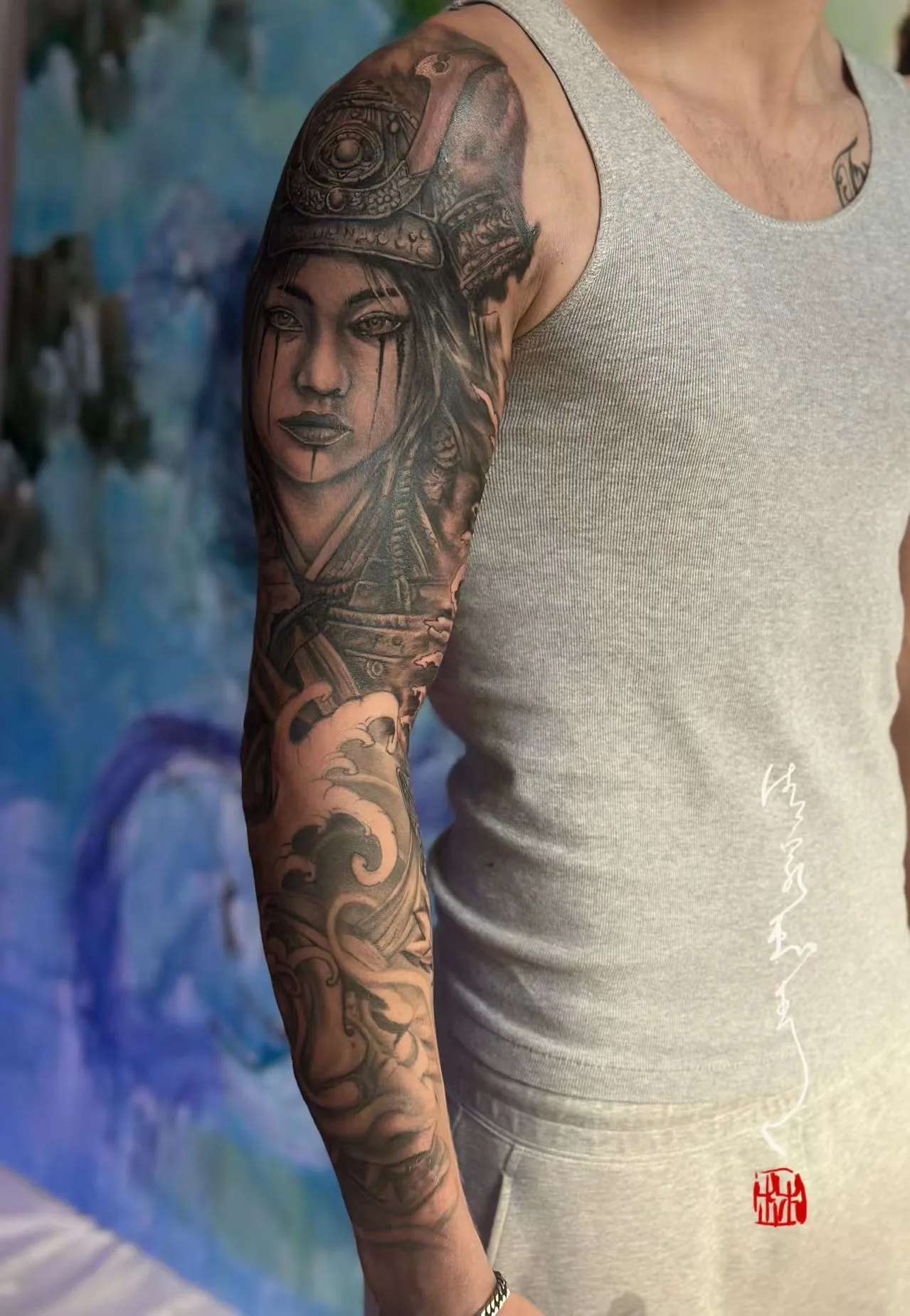 Black-and-grey samurai woman and crashing wave sleeve on a man's arm